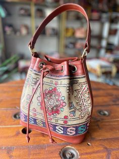 Thank you for visiting our shop!  It's very useful bag as shoulder and as crossbody bag.  This bag is spacious and holds a lot of things. Size         : 30cm x 27cm x 8cm Material  : wool / leather We select beautiful vintage kilims from all over the anatolian area and middle east area. and We do special wash for Kilim rug first, after that cut the kilim to remake unique kilim bags at our atelier  one by one. All products have been produced in a smoke-free environment.  Vintage kilim with colore Bohemian Bucket Shoulder Bag With Large Capacity, Everyday Crossbody Hobo Bag With Leather Handles, Bohemian Travel Bag With Bucket Shape, Bucket Shape Satchel With Detachable Handle For Everyday Use, Bohemian Daily Use Bucket Bag, Everyday Use Bucket Shaped Satchel With Detachable Handle, Everyday Satchel With Detachable Handle And Bucket Shape, Bohemian Bucket Bag With Adjustable Strap For Shopping, Everyday Hobo Bag With Detachable Handle In Bucket Shape