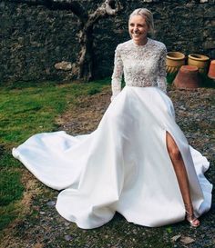 a woman in a white wedding dress posing for the camera with her leg on the ground