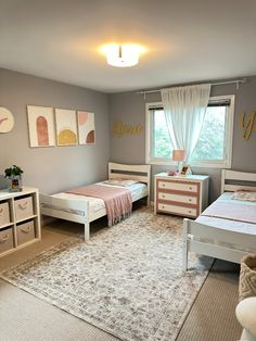 a bedroom with two twin beds and a rug on the floor in front of windows