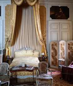 an ornately decorated bedroom with gold drapes