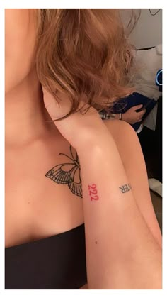 a woman with a butterfly tattoo on her left arm and right arm behind her head