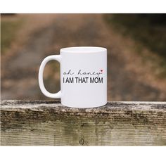 a white coffee mug with the words ok home i am that mom printed on it