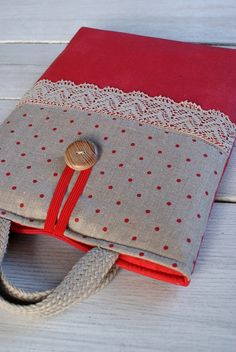 a red and gray bag with a wooden button on it