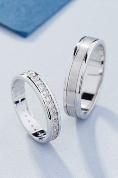 two white gold wedding rings with diamonds on the inside and outside, sitting next to each other