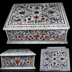 three white and red boxes with floral designs on the top, one is decorated with flowers