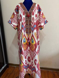 This dress is made of cotton ikat fabric.In Uzbek tradition, women sewed dressed from  these fabrics and wore this type  of dresses to weddings.By this time,girls and women are wearing dresses from vintage loving. Care;dry cleaning only. Length;125cm  / 49inches. Sleeve:37cm  /14,5inches. Chest:134cm/53inches. Size:Oversize. Every item will be shipped from Uzbekistan via postal service. Tracking number will be provided. PROCESSING TIME; 1-2 WORK DAYS. SHIPPING TIME; 2-4 WEEKS. SHIPPING COST; $25 for 1set. $15 for each additional item. Bohemian Maxi Dress For Traditional Ceremonies, Red Folk Style Maxi Dress, Cotton Dresses With Traditional Embroidered Patterns, Cotton Dresses With Multicolor Embroidery And Traditional Patterns, Folk Style Cotton Kaftan With Woven Motifs, Traditional Multicolor Cotton Maxi Dress, Bohemian Cotton Handloom Dress, Traditional Ikat Print Patterned Dress, Traditional Patterned Dress With Ikat Print