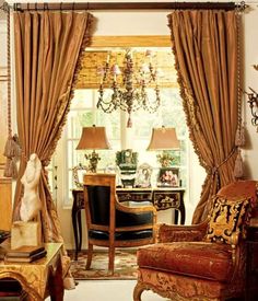 a living room filled with furniture and a chandelier hanging from the ceiling next to a window