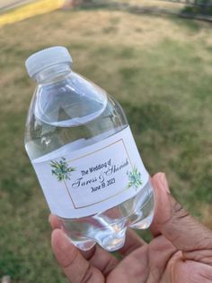 a person holding a bottle of water in their left hand and label on the top