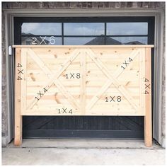 a large wooden gate with numbers on it in front of a brick wall and garage door