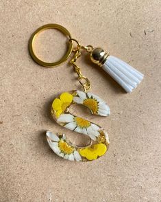 a keychain with flowers and a tassel hanging from it's side