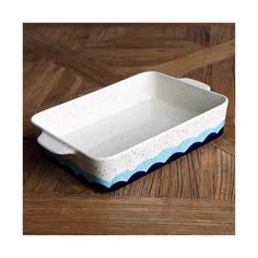 a white and blue dish sitting on top of a wooden floor