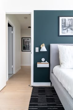 a bedroom with blue walls and white bedding