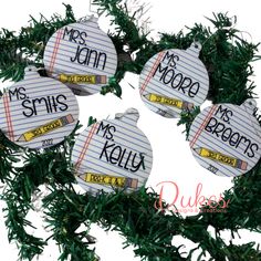 four ornament hanging from a christmas tree with writing on the front and back