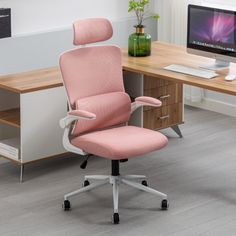 a pink office chair sitting in front of a computer desk