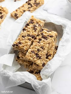 chocolate chip granola bars are stacked on top of each other in paper wrappers