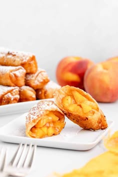 two plates with pastries on them next to some peaches