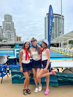 three girls are posing in front of a surfboard