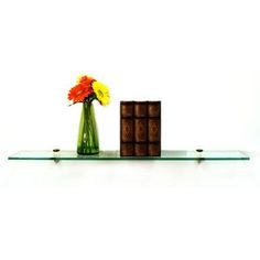 there is a vase with flowers and some chocolates on the glass shelf next to it