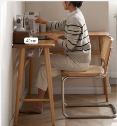 a woman sitting at a desk with a laptop computer and coffee maker in front of her