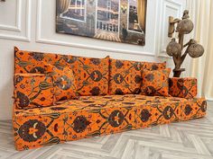 an orange couch sitting on top of a hard wood floor