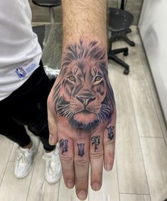 a man's hand with a tiger tattoo on it and the other hand is in front of him