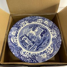 a blue and white plate in a cardboard box