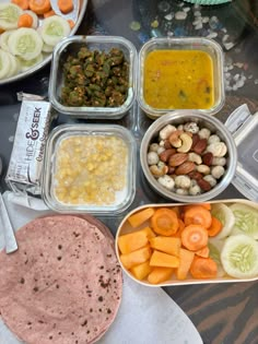 a table topped with lots of food and containers filled with different types of foods next to each other