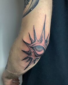 a man with a tattoo on his arm holding a cell phone in one hand and an alien eye in the other