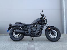 a black motorcycle parked in front of a garage door