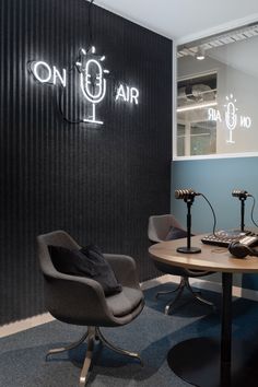 a table with two chairs and microphones in front of a sign that says on air