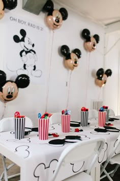 a mickey mouse themed birthday party with popcorn buckets and black and white striped paper cups