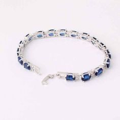 This stunning bracelet features 17 oval shaped Austrian Crystals in brilliant blue colors. Each stone is accented with two smaller crystals on each side creating the perfect contrast to the brightly colored stones. Deep, rich blue stones paired with vibrant, light catching cz diamonds create a luxurious piece for any occasion. Clasp closure for added security. Fit for royalty and a beauty for any occasion. Material: 14K White Gold Plated. Stones: 7mm x 5mm Austrian Cystal and 1.5 mm CZ Stones. S Blue Crystal Bracelets For Formal Occasions, Blue Sparkling Stones Bracelet For Formal Occasions, Blue Gemstone Bracelet In Cubic Zirconia, Blue Cubic Zirconia Crystal Bracelet, Oval Blue Gemstone Bracelets, Blue Oval Bracelet For Anniversary, Blue Oval Bracelets For Anniversary, Blue Sapphire Oval Bracelets, Formal Blue Bracelets With Gemstone Accents