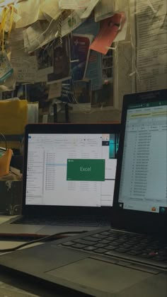 an open laptop computer sitting on top of a wooden desk next to a desktop computer