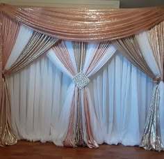 a white and gold wedding backdrop with sequins on the top, along with sheer curtains