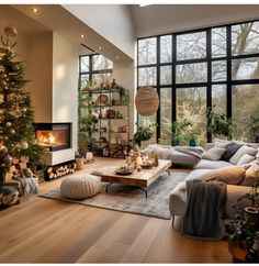 a living room filled with lots of furniture and a christmas tree in front of a large window