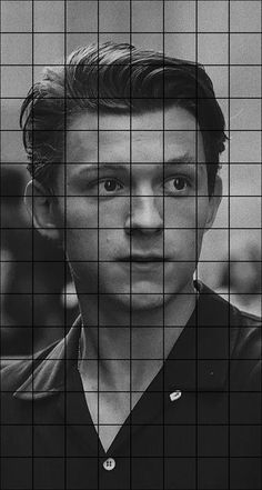 a black and white photo of a man looking at the camera through a grid pattern