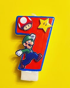 an image of a mario birthday candle on a yellow background