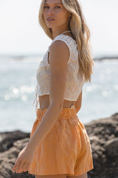 Introducing the Ojai Sun Cotton Eyelet Tank Top. This cropped tank features delicate eyelet detailing and a front tie. Perfect to tie over your swimsuit this summer. Pair with our Capri Linen Shorts to get this look! Day Out Tie Waist Cropped Top, Cropped Tie Waist Crop Top For Day Out, Beach Crop Top With Tie Back, Beach Tie Back Crop Top, Cropped Tie Back Crop Top For The Beach, Tie-back Cropped Crop Top For The Beach, Sleeveless Crop Top For Beach Season, Sleeveless Crop Top For Beach Day Out, Summer Poolside Tie Back Tops