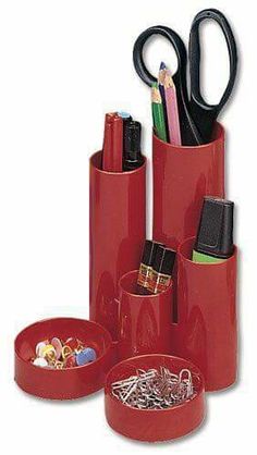 red pen holder with scissors and pencils in it