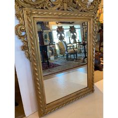 a large gold framed mirror sitting on top of a table