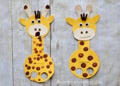 two giraffes made out of paper on wooden boards with holes in the middle