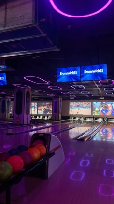 bowling alley with neon lights and colorful bowling balls on the floor in front of them