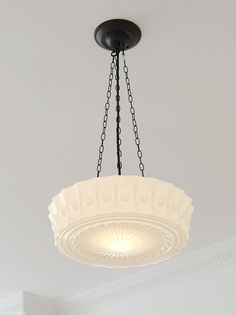 a chandelier hanging from the ceiling in a room with white walls and ceilings