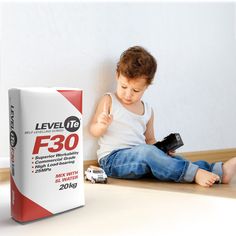 a little boy sitting on the floor with a remote control in his hand and a box of level it f3o next to him