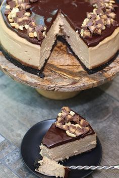 a chocolate and peanut butter cheesecake on a black plate with a slice missing from it