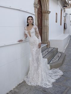 a woman in a wedding dress leaning against a wall