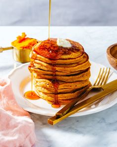 a stack of pancakes with syrup being drizzled on top