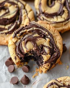 chocolate swirled cookies on top of parchment paper with one bite taken out and the other half eaten