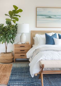 a bedroom with a bed, two nightstands and a potted plant