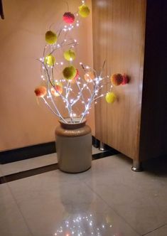 a vase filled with balls and lights on top of a tiled floor